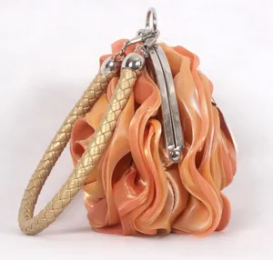 Macro detail of satin floral petals on evening bag with gold woven wrist strap