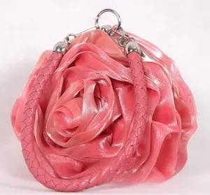 Macro shot of pink silk rose flower evening bag with satin petals and top handle