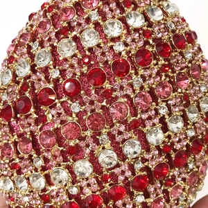 Macro detail of luxury pineapple evening bag with red crystals and gold claw setting