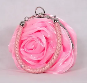 Close-up of pink satin rose evening bag with woven handle and metallic ring detail