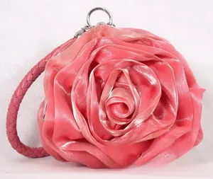 Detail of pink satin rose evening bag showing layered fabric petals and braided handle