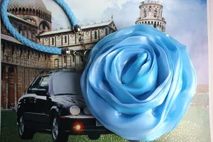 Detail of blue satin 3D flower charm with woven rope and silver metal ring clasp