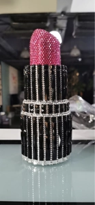Macro detail of luxury lipstick-shaped clutch featuring premium pink and black rhinestones