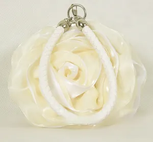 Detailed view of the 3D satin rose petals and woven handle on the ivory evening bag