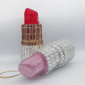Macro detail of luxury lipstick-shaped clutch bags encrusted with sparkling rhinestones