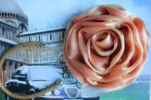 Detail of a champagne gold 3D satin rose flower charm with elegant fabric texture