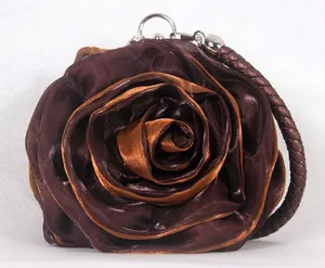 Detailed view of the rose-shaped silk fabric texture and woven shoulder strap on the bag