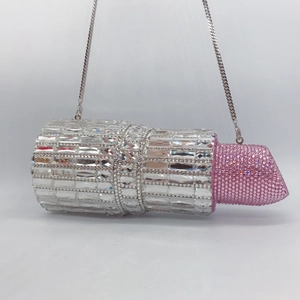 Macro detail of luxury lipstick-shaped evening clutch with sparkling pink and silver crystals