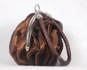 Detailed side view of 3D rose-shaped satin evening bag with woven handle and metallic frame