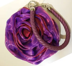 Top view of red and purple silk 3D rose flower handbag with braided handle and metal clip