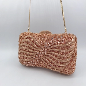 Macro shot of rose gold dinner clutch with sparkling rhinestones and golden chain