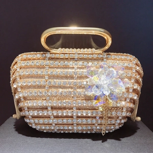 Détail de la pochette de soirée cage dorée avec cristaux étincelants et pompons en métal