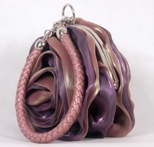 Detail view of purple silk rose evening bag featuring pink braided handle and metal frame