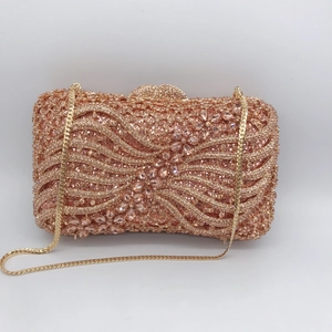 Close-up of rose gold clutch with sparkling rhinestones and wave texture detailing