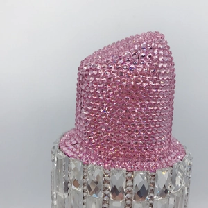 Close-up of luxury lipstick clutch bag with pink and clear crystals encrusted details