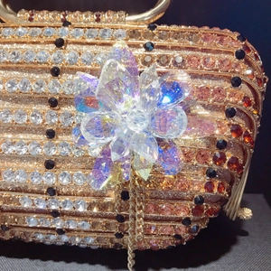 Gros plan sur la pochette de soirée champagne avec fleur en cristal et strass brillants