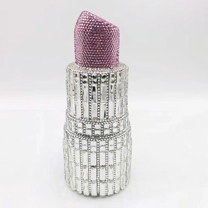 Macro detail of luxury lipstick-shaped clutch bag with pink and white crystals