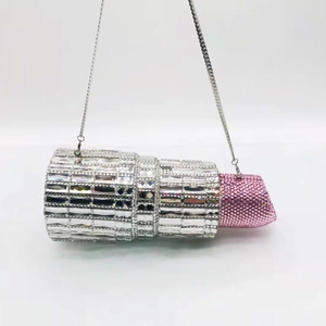 Detailed macro view of pink crystal lipstick-shaped evening clutch with silver chain