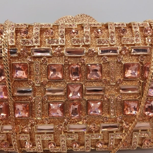 Luxurious champagne gold clutch bag with pink crystals and a fine gold chain strap