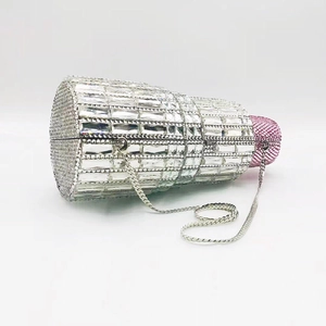 Detailed macro view of crystal-encrusted lipstick evening clutch bag with a metal chain