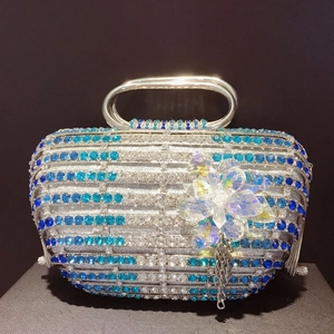 Détail du sac de soirée à rayures bleues en strass avec fleur et franges en métal