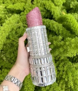 Detailed close-up of a lipstick-shaped evening clutch bag adorned with sparkling rhinestones
