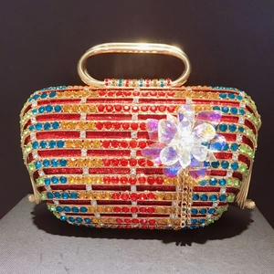 Vue détaillée d'ornement floral en cristal avec pompons dorés sur pochette de luxe