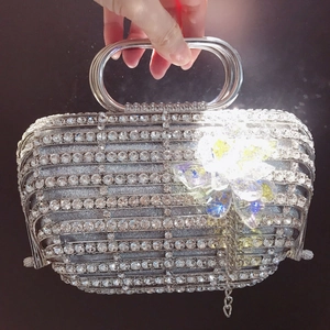 Détail d'une pochette de soirée argentée avec fleur en cristal et strass étincelants