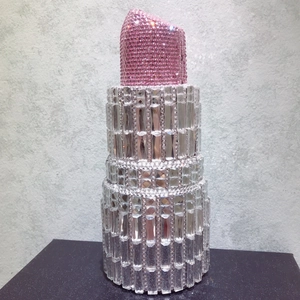 Detailed view of lipstick-shaped evening clutch with pink and clear crystal rhinestones