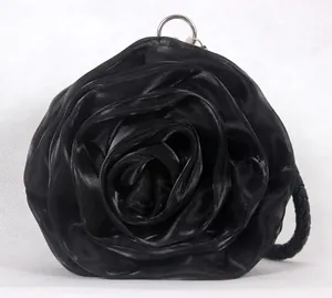 Detail of black rose satin evening bag with silver metal ring and woven handle strap