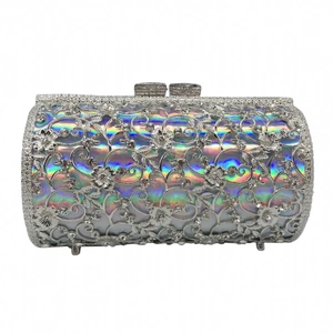 Detailed macro view of the hollow metal floral design and rhinestones on silver evening bag