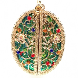 Close-up of hollow metal evening bag with colorful crystals and green iridescent base