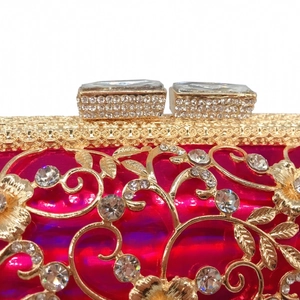 Macro shot of gold hollow floral metalwork with pink crystals and rhinestones