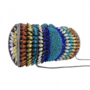 Detailed close-up of a luxury cylindrical evening clutch with vibrant colorful crystals