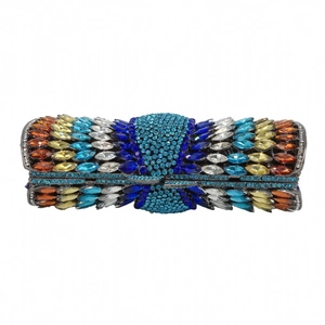 Close-up of colorful crystal marquise gemstones on a luxury cylindrical metal evening clutch