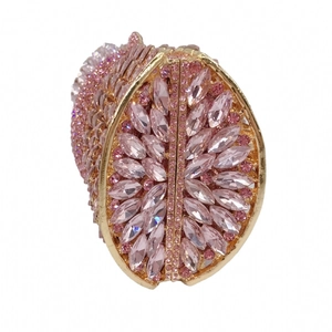 Macro detail of pink crystal rhinestones and gold metal frame on lemon evening bag