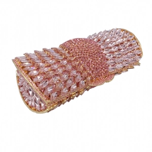 Macro detail of pink crystal rhinestones on a gold metal frame evening clutch bag