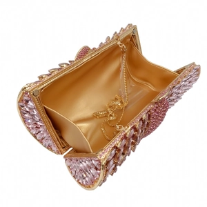 Detailed interior of luxury evening clutch with pink crystals and gold satin lining