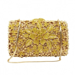 Detailed view of luxury evening clutch featuring golden floral crystals and snake chain