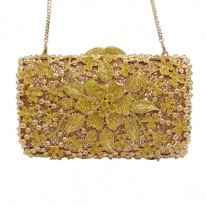 Detail of evening clutch with yellow rhinestones, large floral crystal and gold chain