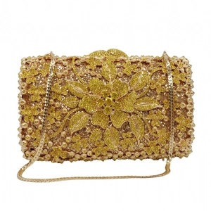 Detailed view of luxury evening clutch featuring golden floral rhinestones and metal chain