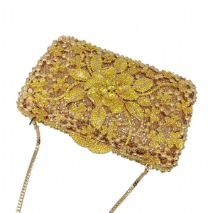 Detailed macro view of 3D floral pattern with champagne crystals and gold snake chain