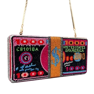 Macro detail of multicolored crystal encrusted hundred dollar bill clutch bag with gold chain