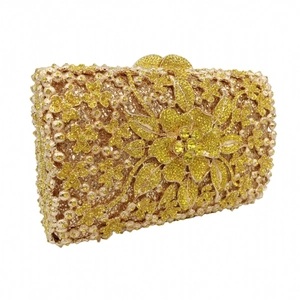 Detail view of the intricate gold flower design and crystals on the clutch bag