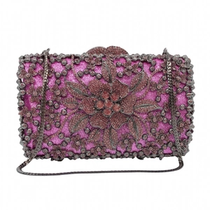 Close-up of fuchsia glitter evening clutch with intricate crystal flower and pink gems