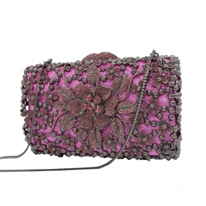 Detail of fuchsia evening clutch featuring hollow flower patterns and sparkling rhinestones