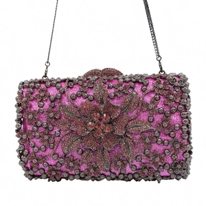Detailed view of the sparkling purple glitter clutch bag with intricate floral rhinestone patterns