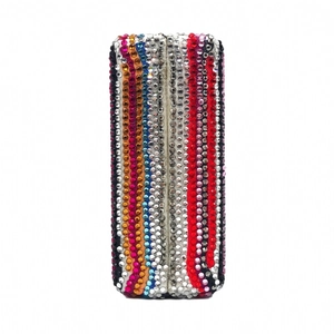 Close-up of a rectangle evening clutch bag with multi-colored rhinestone vertical stripes