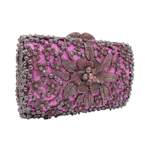 Detail of crystal floral embellishments on a purple glitter evening clutch bag