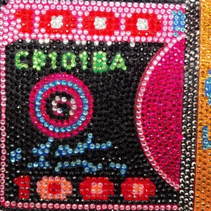 Detailed macro view of the 1000 number design in colorful rhinestones on a clutch bag